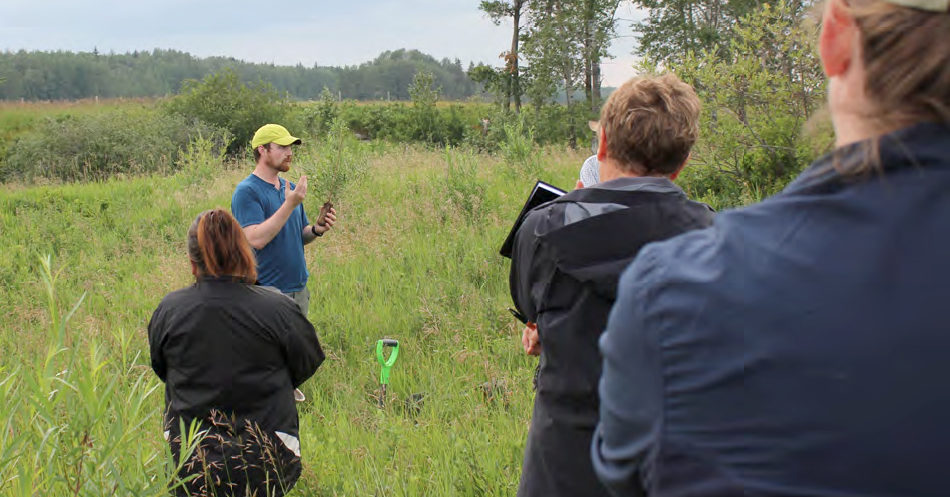 A man in a ballcap lecturing in the watershed.