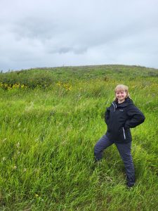 Photo of a BRWA staff member standing in a field of tansy
